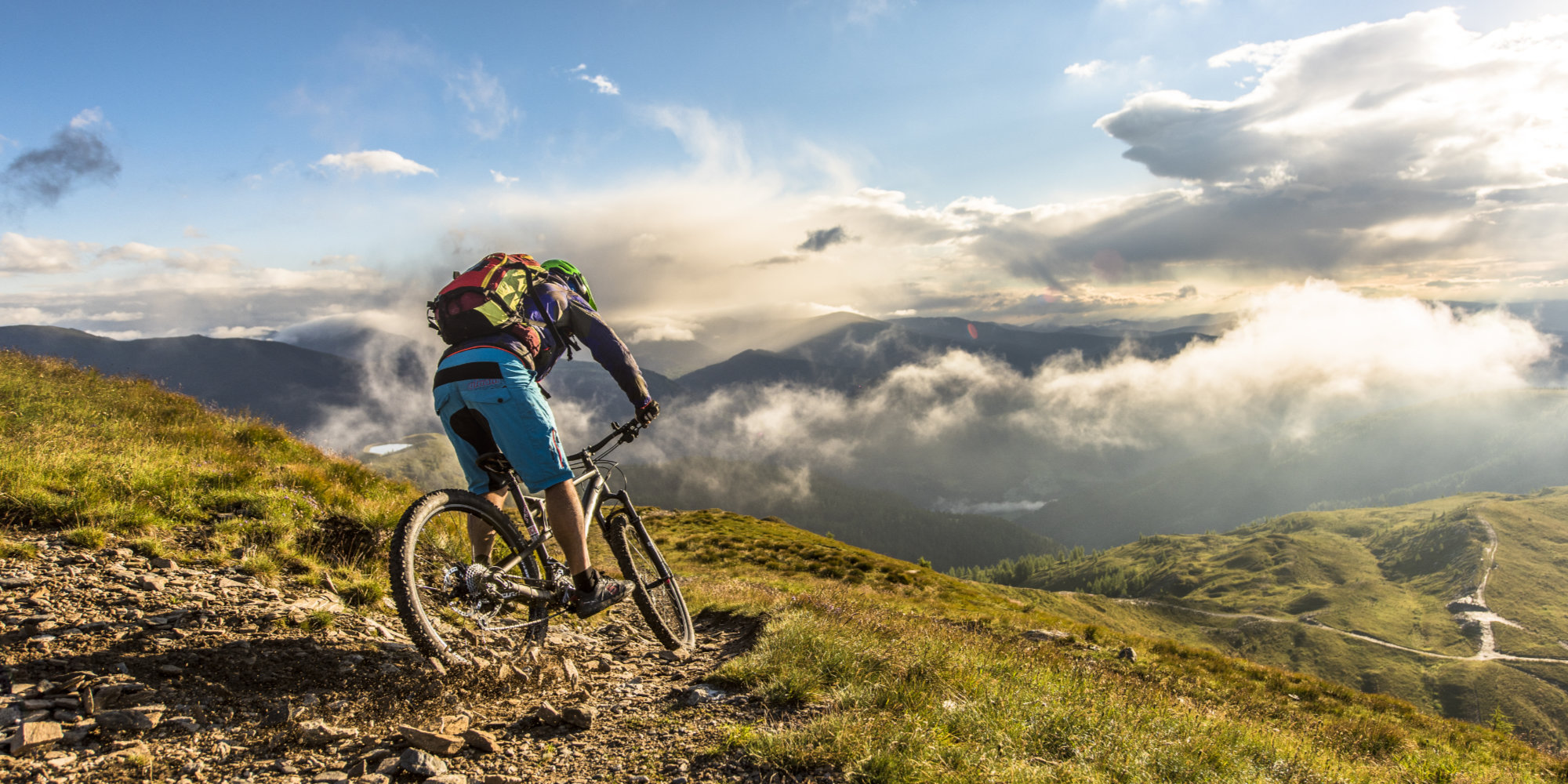 Man on his mountain bike in the mountains above the clouds.